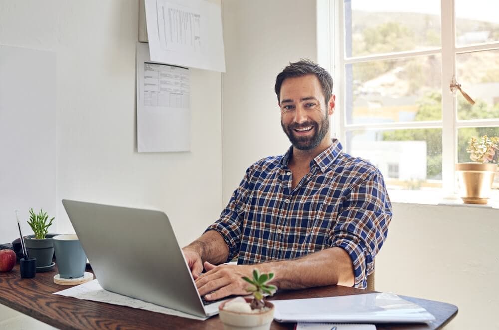 smiling man sitting at office desk